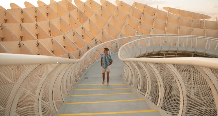 A man is walking down a stairway at Setas De Sevilla in Sevilla, Spain.