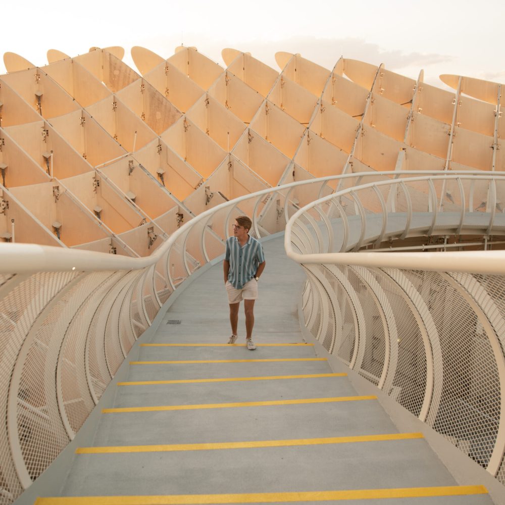 A man is walking down a stairway at Setas De Sevilla in Sevilla, Spain.